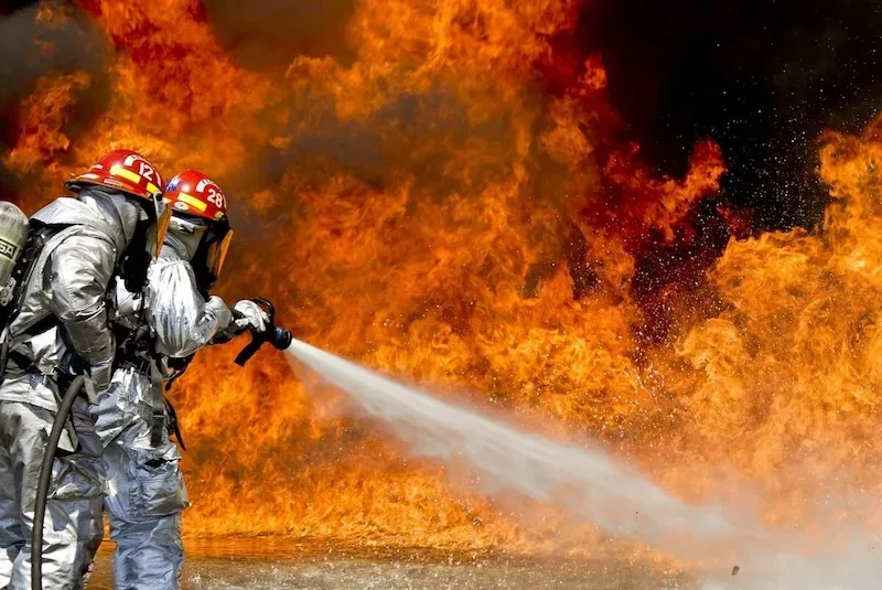 Fire fighter extinguishing fire